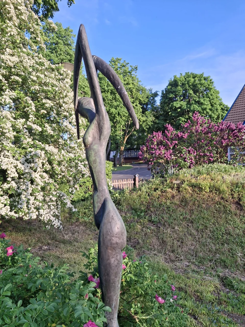 Skulptur und blühender Garten am Haus Aika