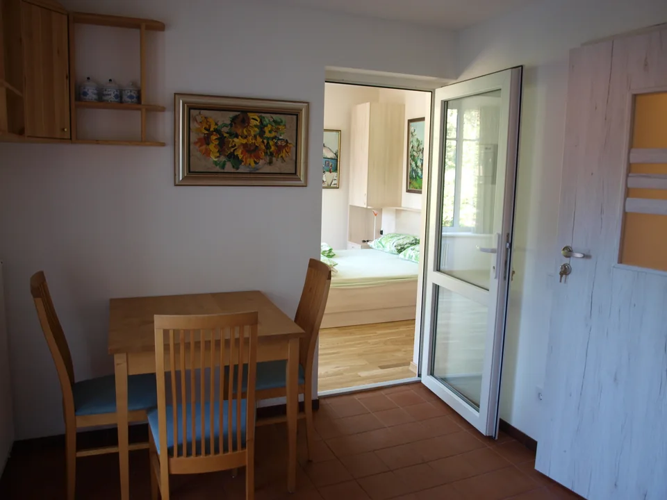Apartment mit Terrasse – Essplatz und Blick ins Schlafzimmer